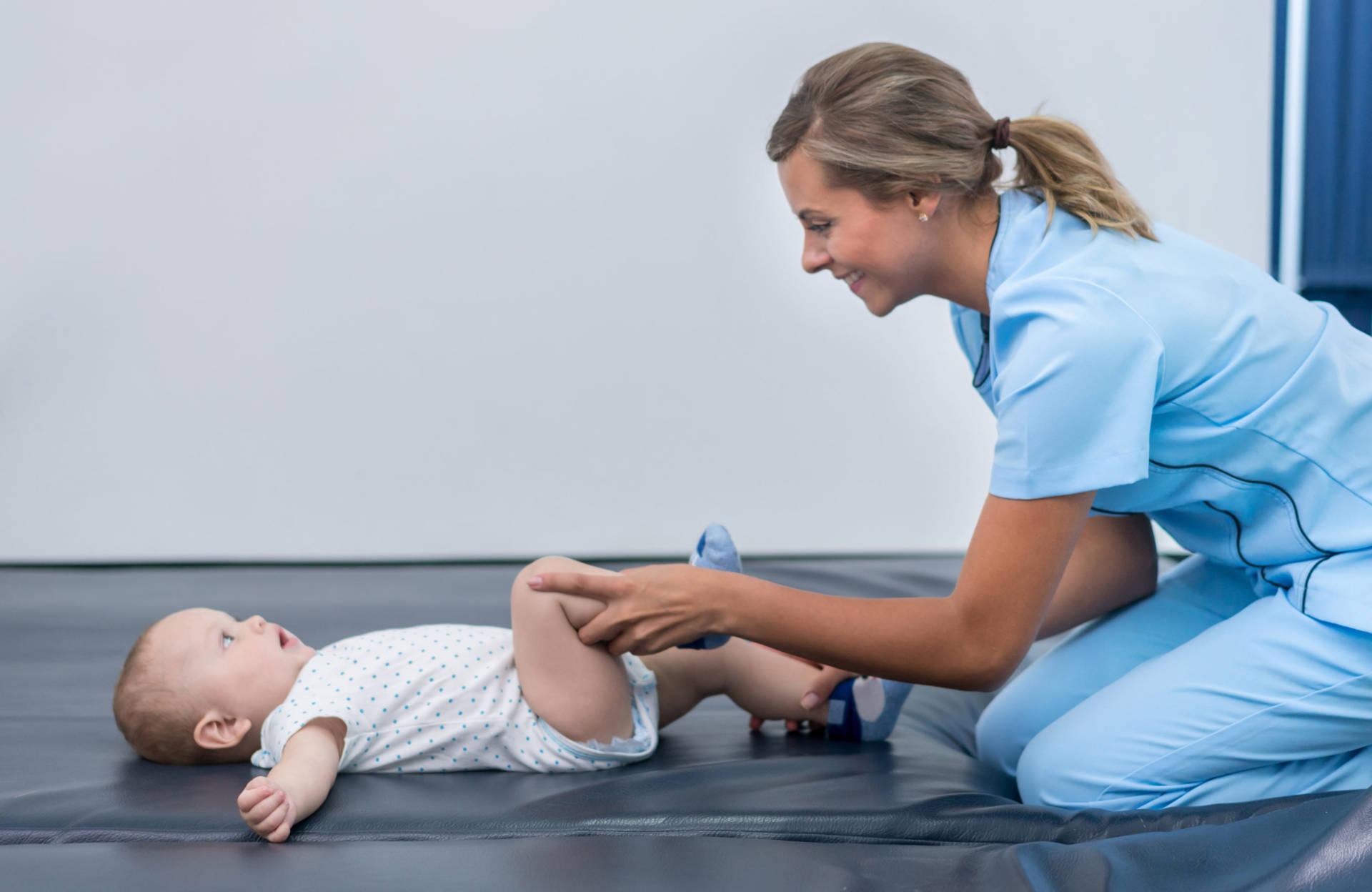 Happy baby in physical therapy with physiotherapist - early stimulations concepts